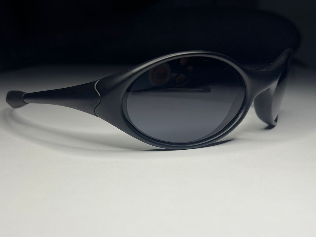 Black sunglasses on a white surface with a dark background