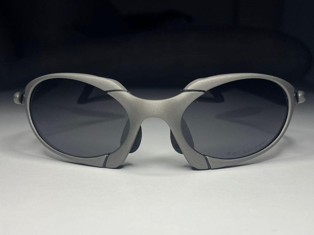 Sunglasses with gray frame and dark lenses on a light gray background