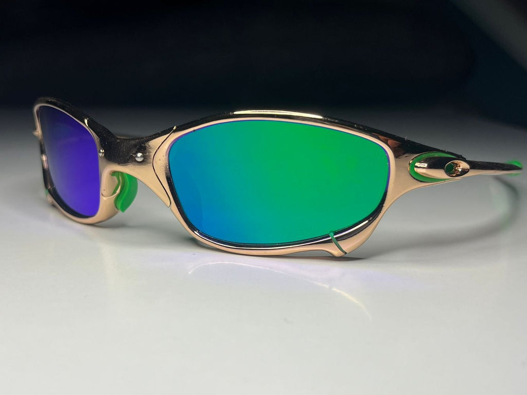 Sunglasses with green lenses and gold frame on a white surface
