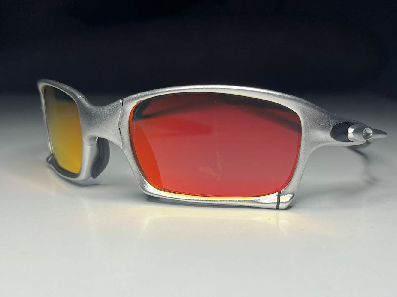 Sunglasses with red and yellow lenses on a white surface