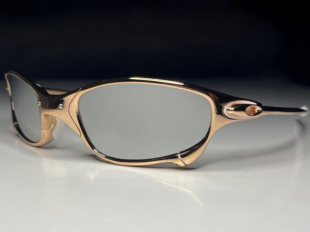 Gold-framed eyeglasses on a white surface with a black background