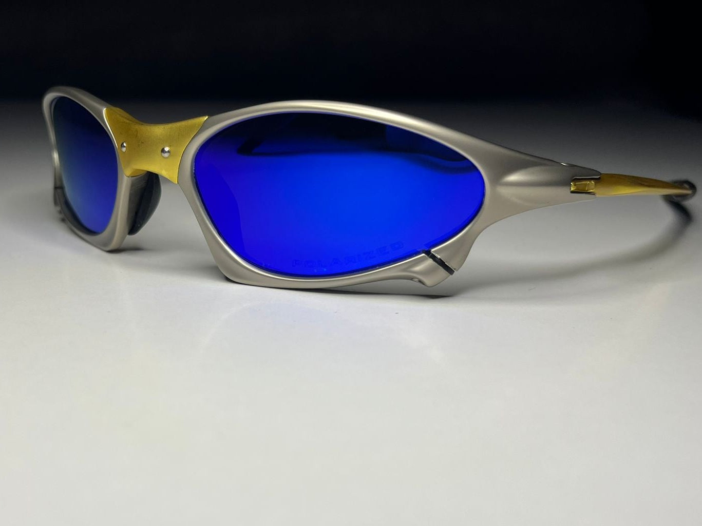 Sunglasses with blue lenses and silver frame on a white surface