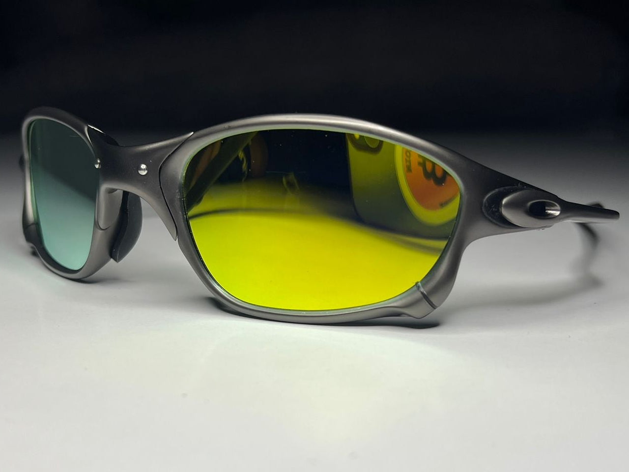 Sunglasses with reflective yellow lenses on a white surface