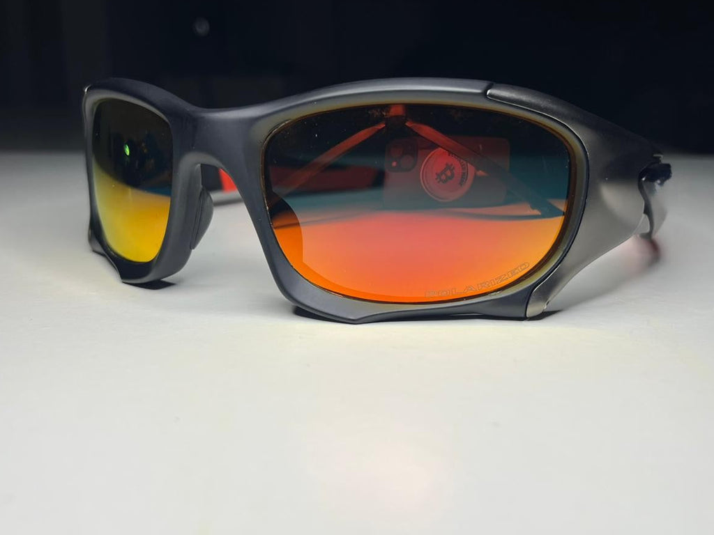 Sunglasses with orange-tinted lenses on a white surface