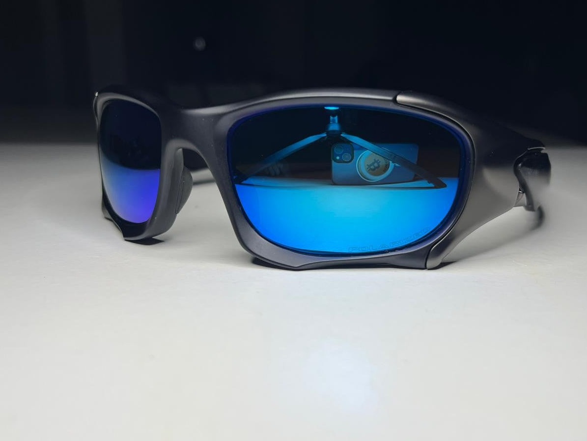 Black sunglasses with blue reflective lenses on a white surface