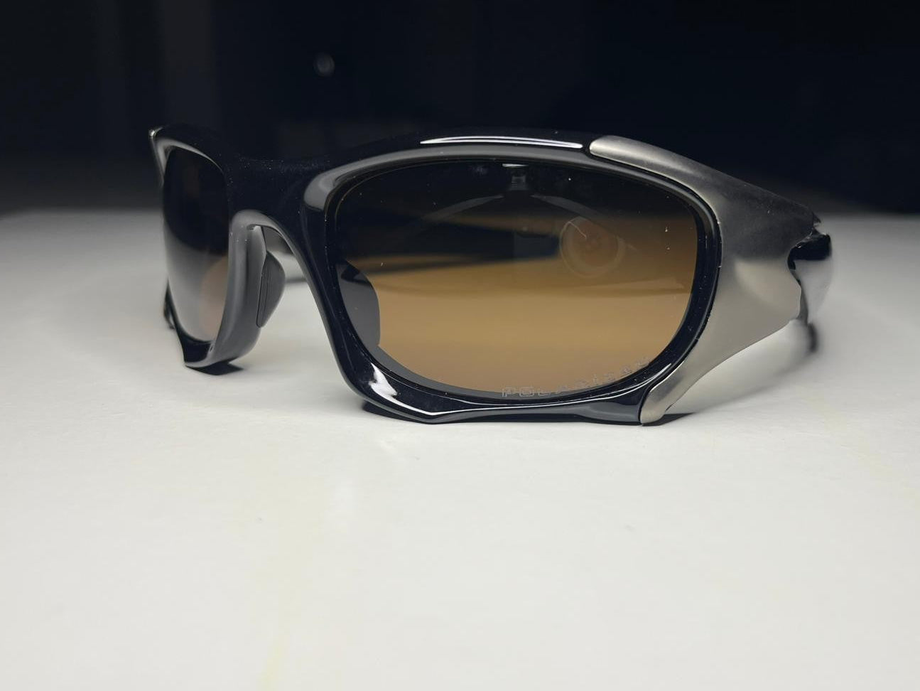 Sunglasses with dark lenses on a white surface