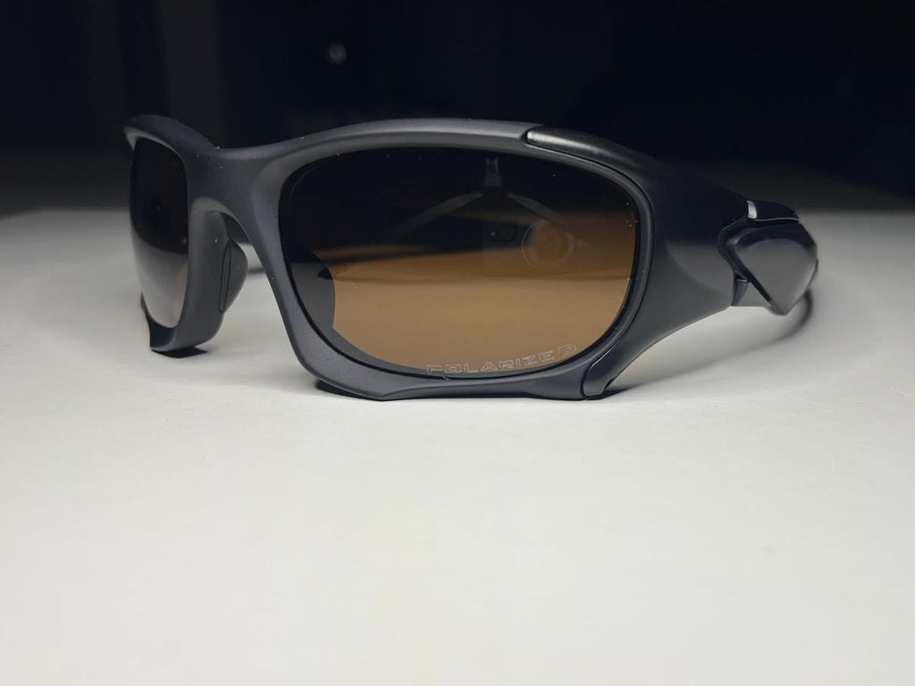 Black sunglasses with brown lenses on a white surface with a black background