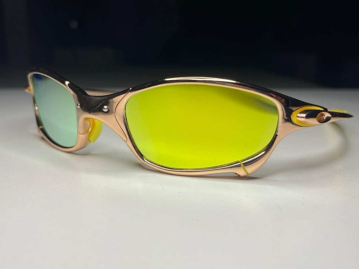 Sunglasses with gold frame and green lenses on a white surface with black background
