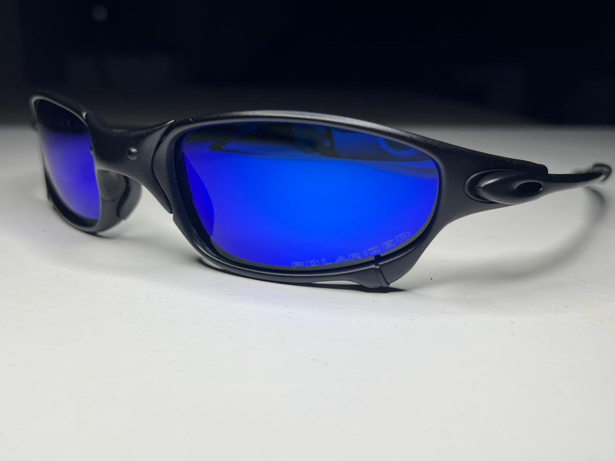 Black sunglasses with blue lenses on a white surface